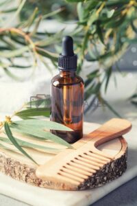 amber glass transparent bottle with eucalyptus leaves and wooden hair brush royalty free images